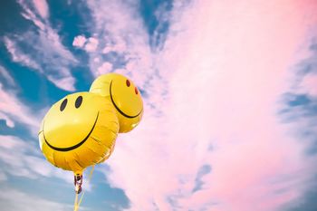 happy-smiley-face-balloons-against-colorful-cotton-royalty-free-image-1677446093.jpg